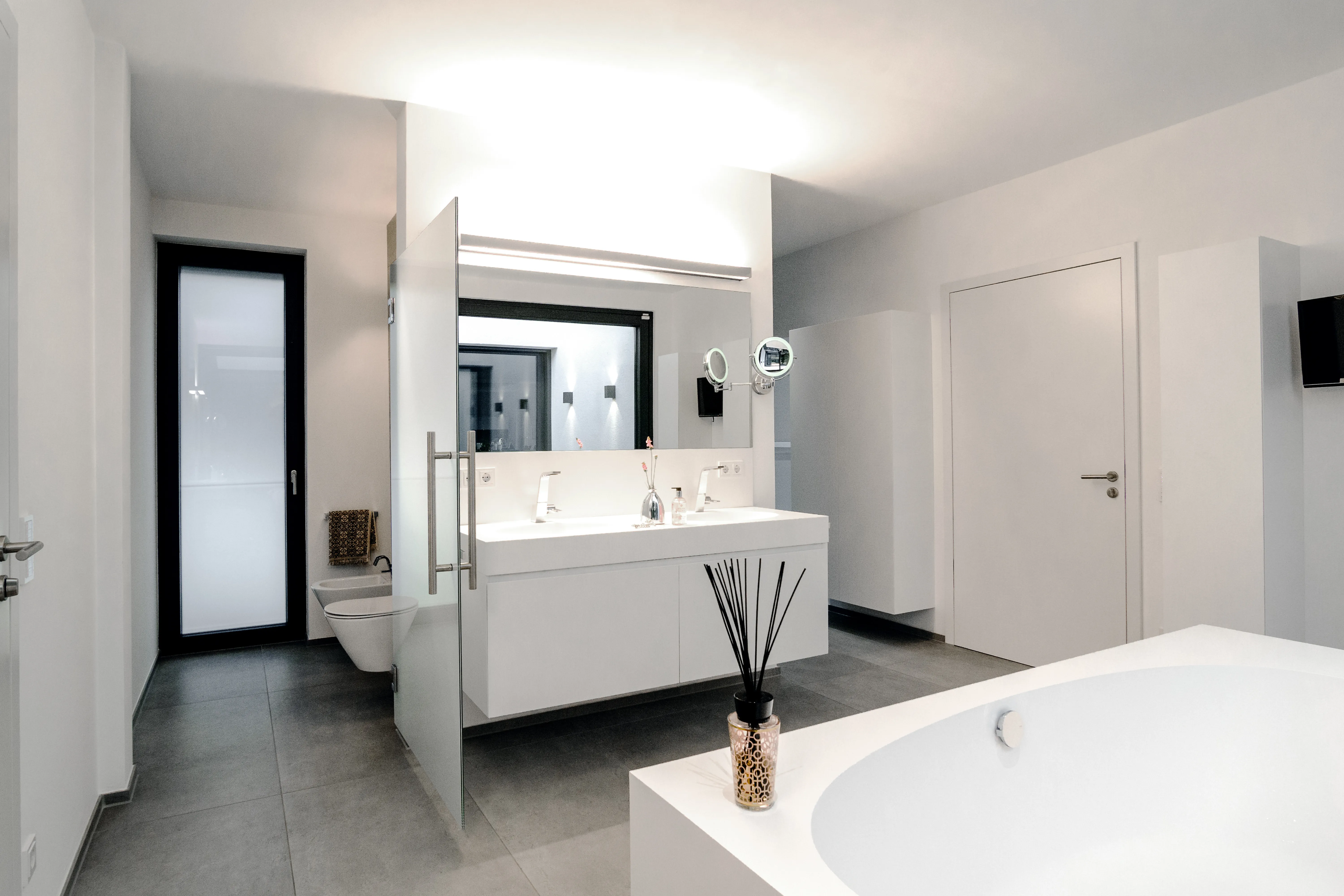 Großzügiges Designerbad mit freistehender Badewanne, Doppelwaschtisch und bodengleicher Dusche.