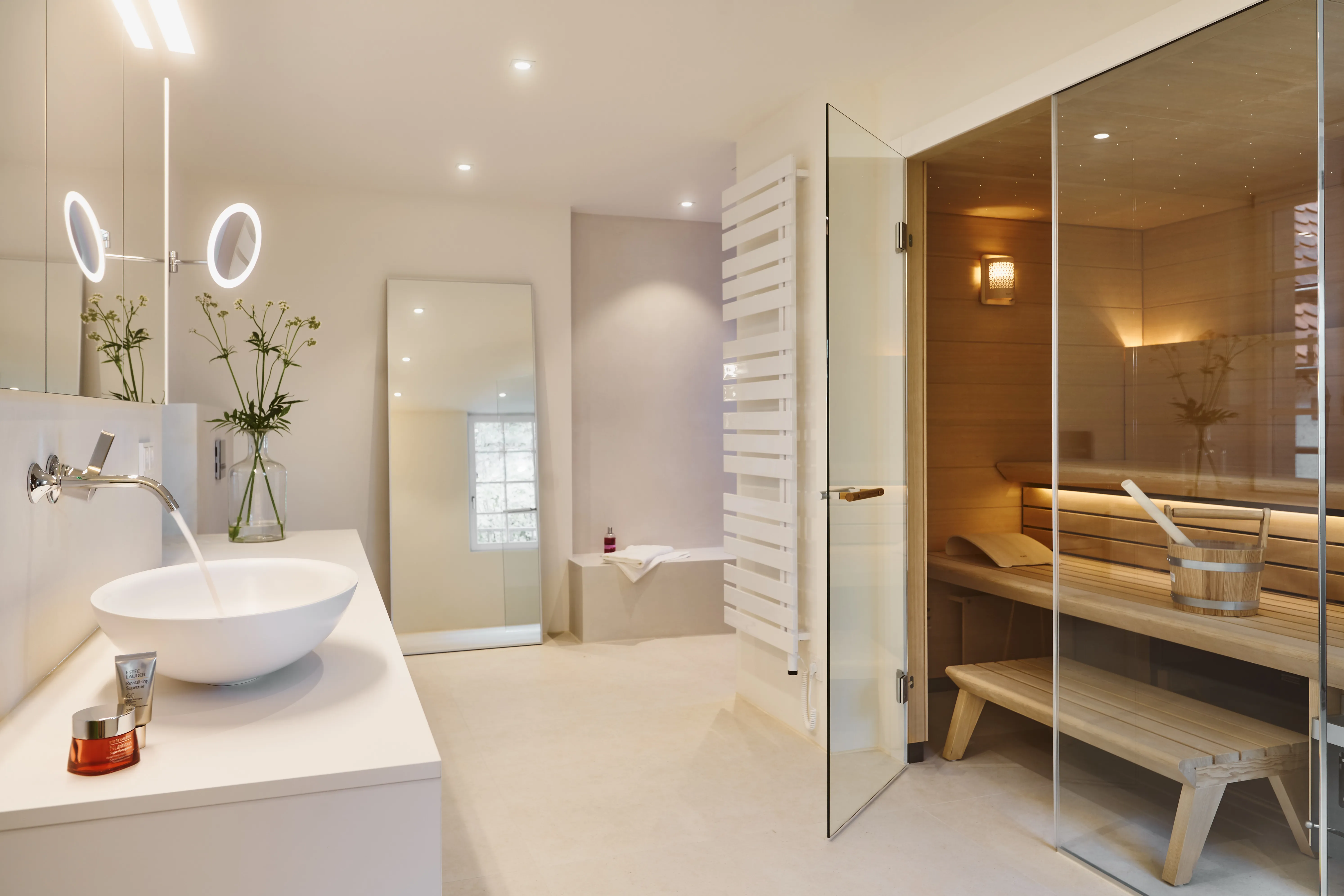 Exklusives Wellnessbad mit integrierter Sauna, Waschtisch und moderner Badgestaltung.