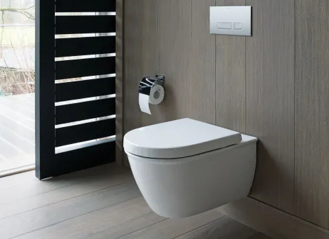 Ein wandmontiertes WC der Duravit Darling New Serie in einem modernen, holzverkleideten Bad.