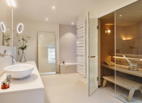 Exklusives Wellnessbad mit integrierter Sauna, Waschtisch und moderner Badgestaltung.